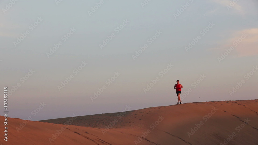 Running man - Jogging athlete runner in desert sand dunes. Fit athletic male fitness model training. Sport in amazing extreme desert landscape nature at sunset Running man - Jogging athlete runner in desert sand dunes. Fit athletic male fitness model training. Sport in amazing extreme desert landscape nature at sunset