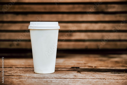 Paper coffee cup from coffee shop on wooden background