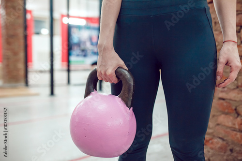 Sport girl is preparing to exercise with kettlebel photo