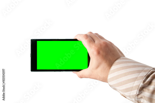 Man holds in hand smartphone in landscape mode with green screen isolated on white. Chroma key screen for placement of your own content.
 photo