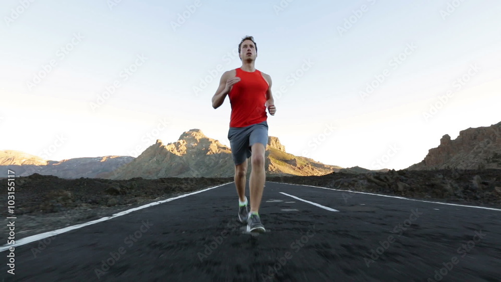 Runner man running on road training for marathon run. Sporty fit caucasian male fitness sport model working out outside in full length.