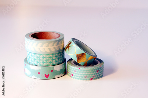 Piccola pila di rotoli di nastro adesivo washi tape. Tonalità verde e azzurro. Sfondo bianco