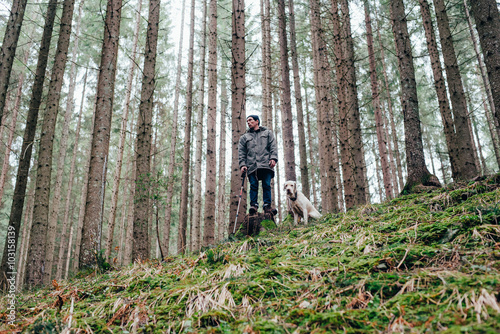 man and labrador dog walking in mountains