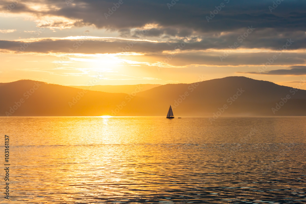 Sailing ship on the lake at sunset skyline