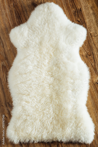 sheepskin carpet on wooden background