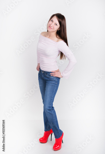 beautiful slim girl in denim pants and red high-heeled shoes and t-shirt