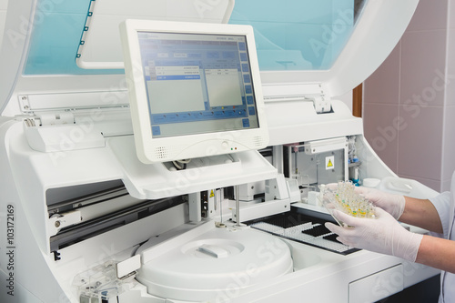 Lab tech loading samples into a chemistry analyzer