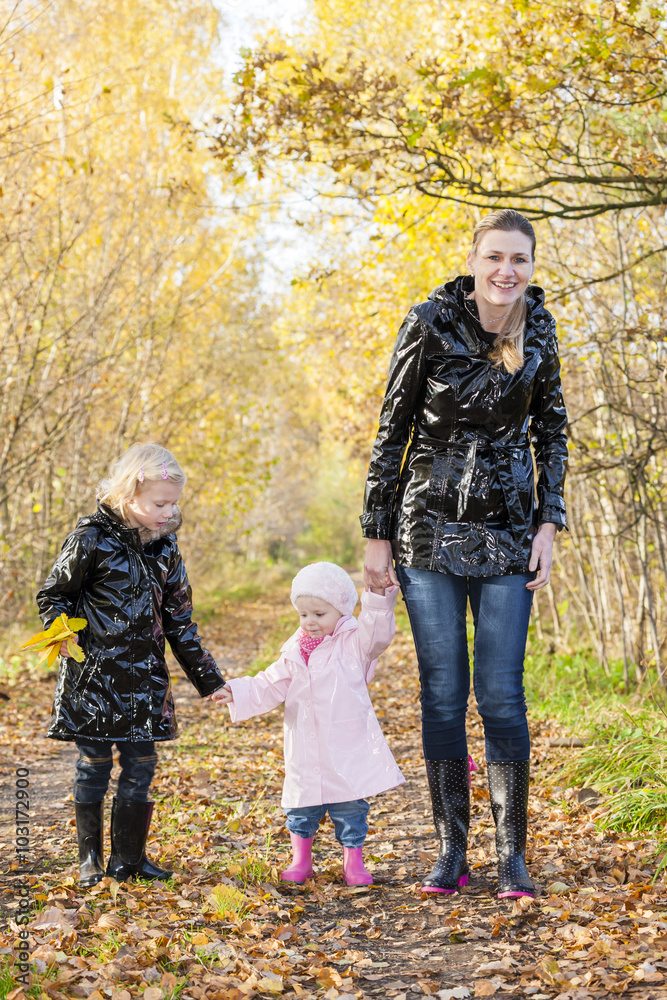 mother with her daughters in autumnal nature