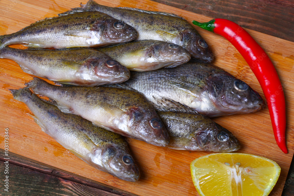raw redfish ruff fish on the kitchen table with vegetables and lemon raw redfish ruff fish on the kitchen table with vegetables and lemon