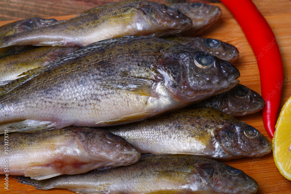 raw redfish ruff fish on the kitchen table with vegetables and lemon raw redfish ruff fish on the kitchen table with vegetables and lemon