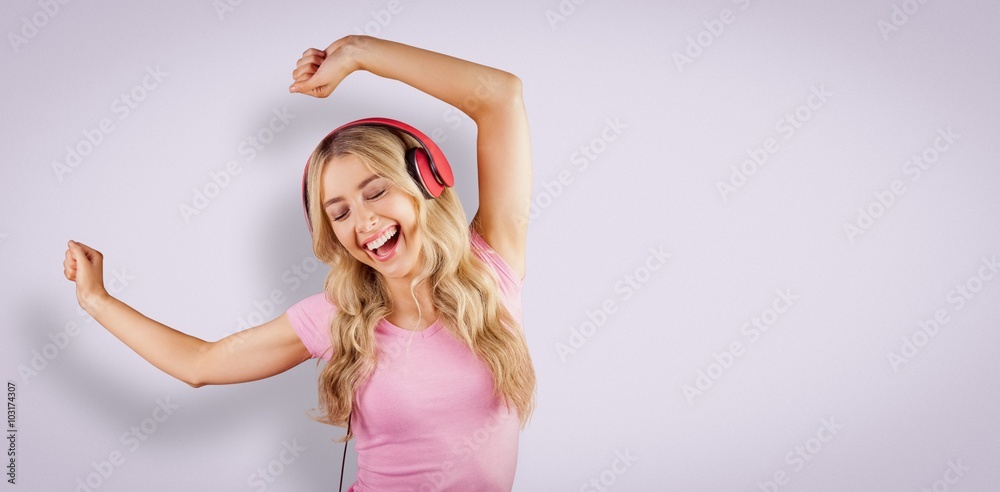 Fototapeta premium Composite image of beautiful woman dancing with headphones