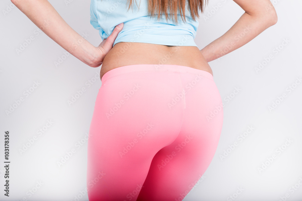 beautiful slender athletic girl in pink leggings, a blue tank top and  colorful Sneakers. nice pop, back view Stock Photo