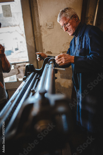 Foto Senior tinsmith in his workshop.