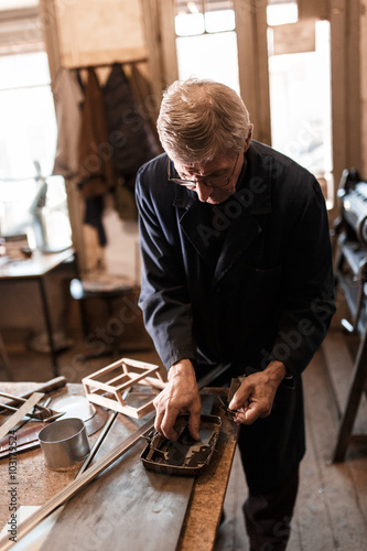 Senior tinsmith in his workshop. photo