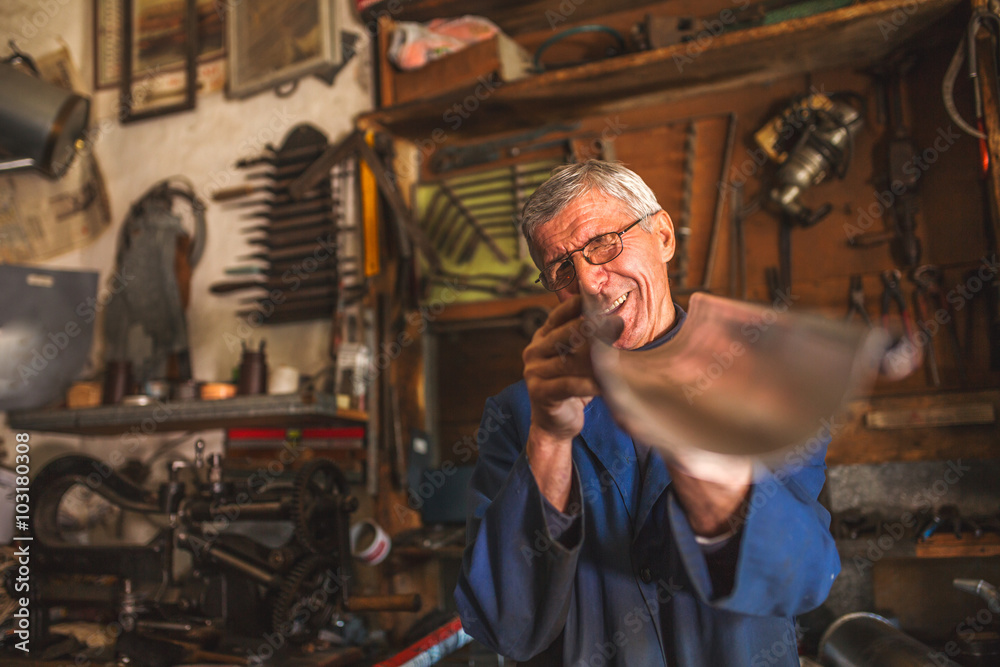 Foto Senior tinsmith in his workshop.