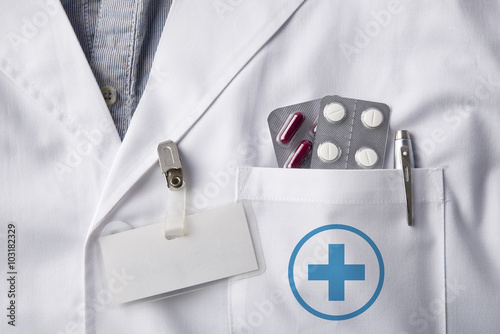 Fotografija Gown doctor with pills and identification tag blank