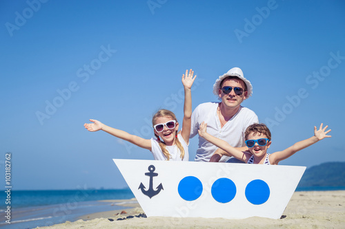 Father and children playing on the beach at the day time. © altanaka