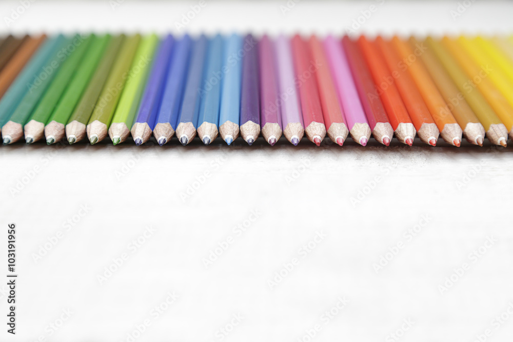 Row of several colored pencils on a wooden old white wooden table Row of several colored pencils on a wooden old white wooden table