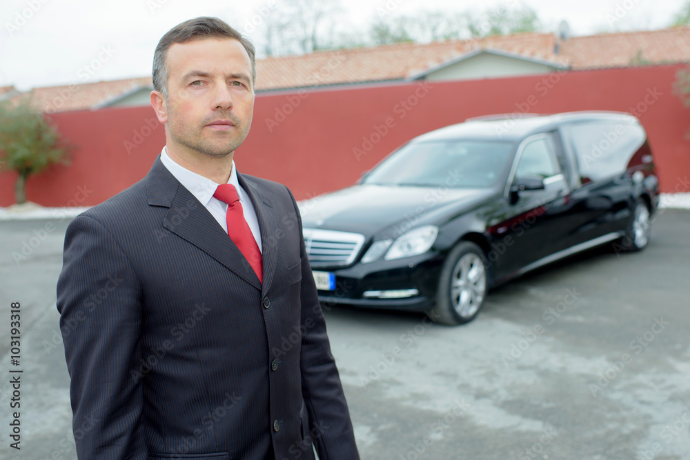 Portrait of funeral director in front of hearse Portrait of funeral director in front of hearse