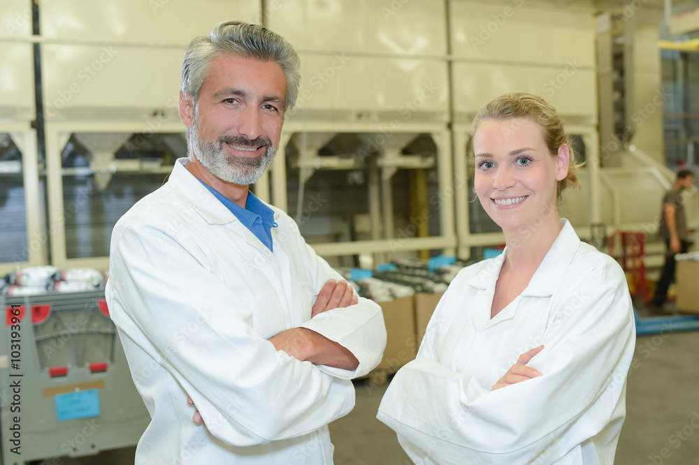 Portrait of two workers in white coats Portrait of two workers in white coats