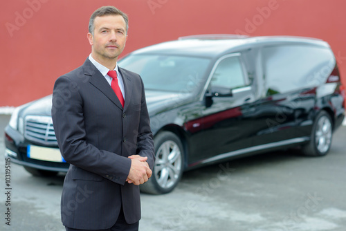 Portrait of undertaker, hearse in background photo