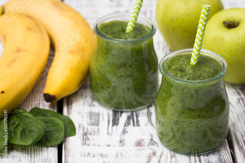 Green smoothie with apple,banana and spinach on a light backgrou