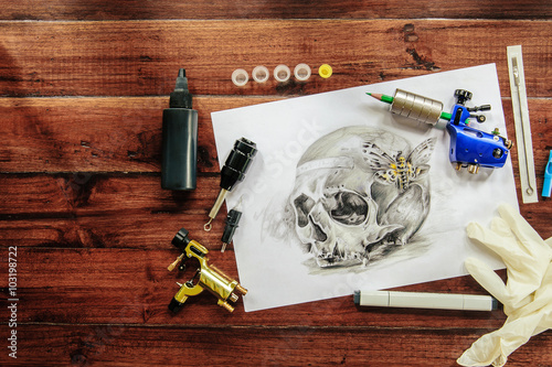 Obraz na płótnie skull tattoo sketch with rotary machines, needles, grips on wooden background w salonie
