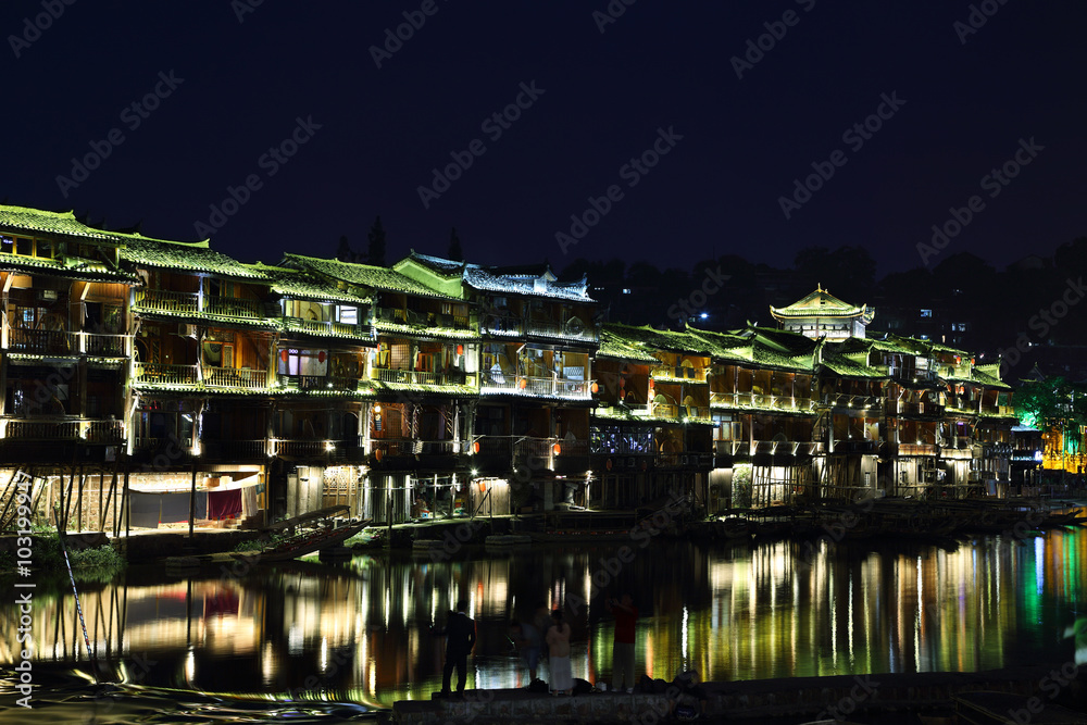 View of illuminated riverside houses in Fenghuang
