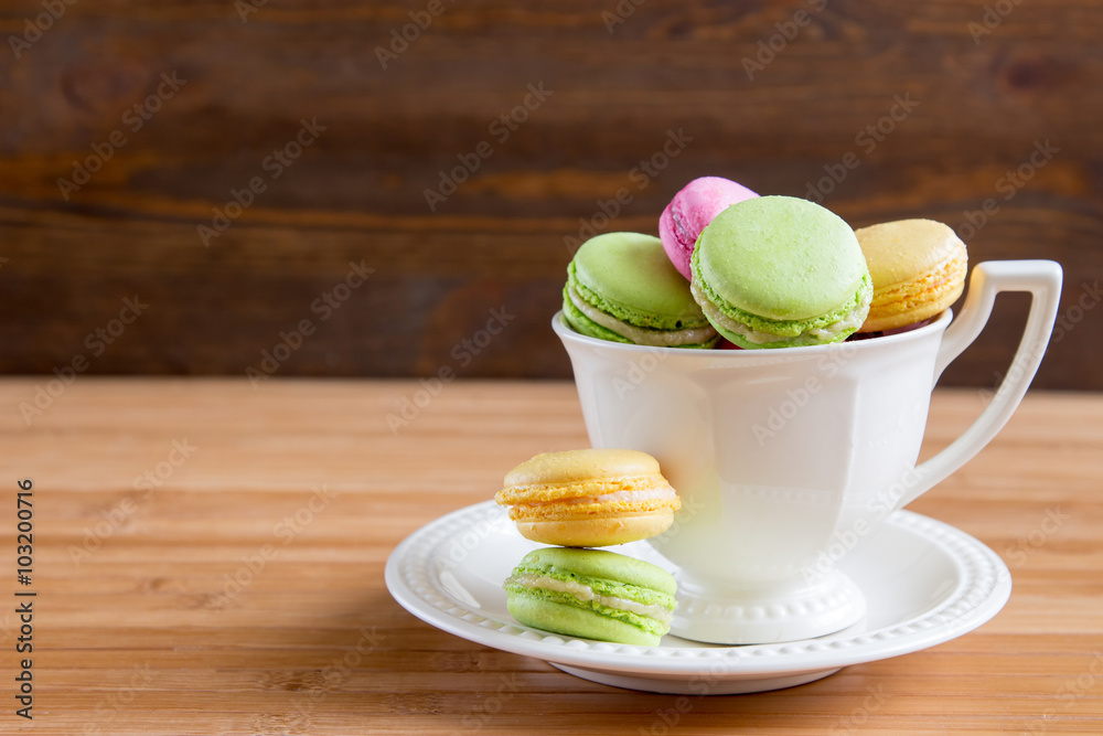 Some macaroons at white tea cup Some macaroons at white tea cup