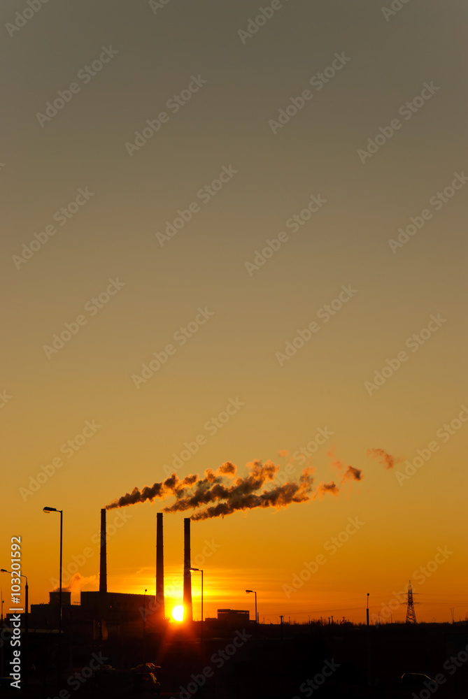 Fototapeta premium Sunset for industrial buildings with smoking pipes