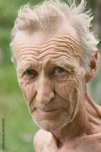An elderly white-haired, unshaven man