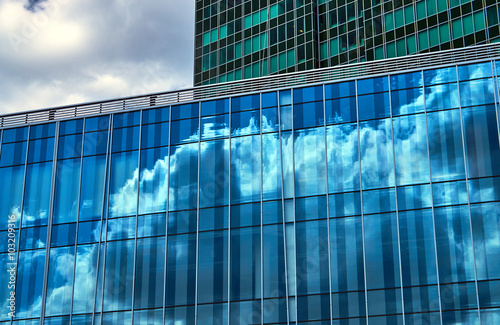 Reflection of the sky and clouds in Glass facade of a building in Poznan . photo