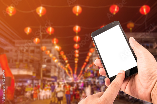 Photography Man hand hold blank touch screen smart phone in china town.