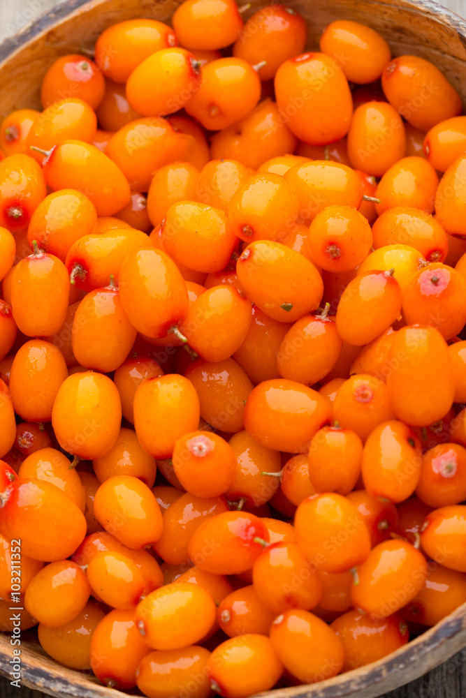 Buckthorn berry basket on wooden background. Buckthorn berry basket on wooden background.