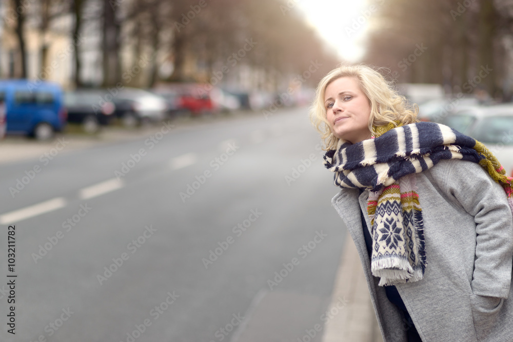 Attractive blond woman waiting for a cab or a lift Attractive blond woman waiting for a cab or a lift