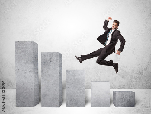 Successful business man jumping over charts on background