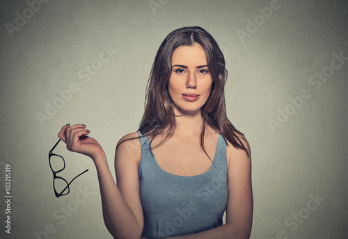 attractive woman holding pair of glasses she doesn't need anymore