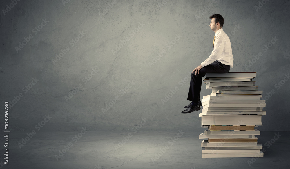 Stylish male seated on books Stylish male seated on books