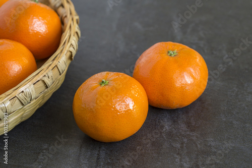 Mandarin Oranges with a bamboo tray on the slate background
