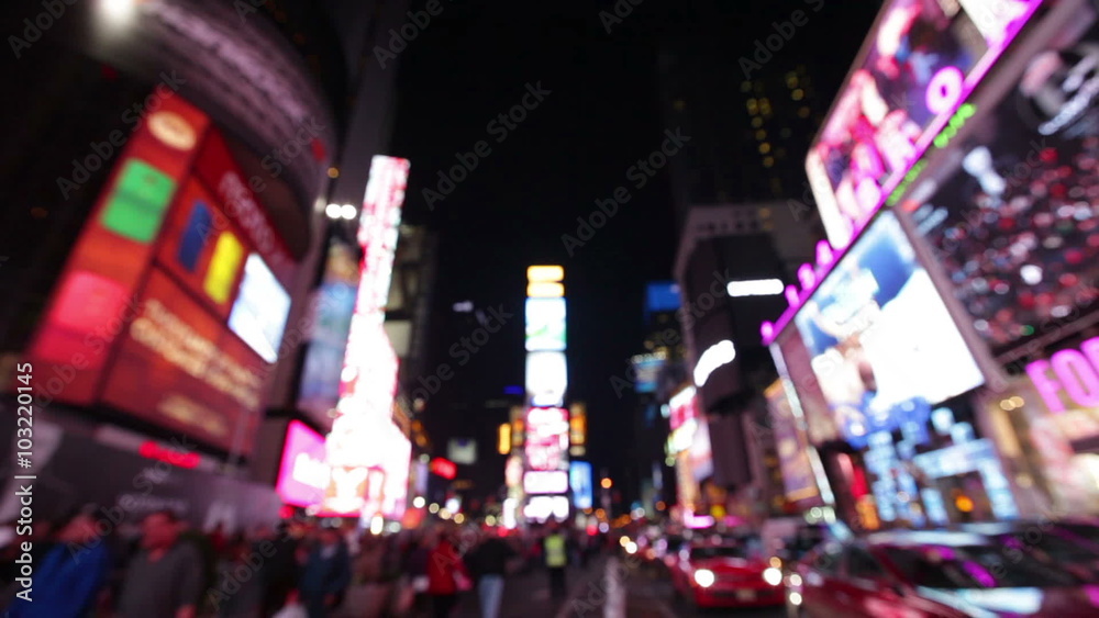 New York City, Times Square, Manhattan background out of focus with blurry unfocused city lights and billboards. City at night with cars and pedestrians people walking.