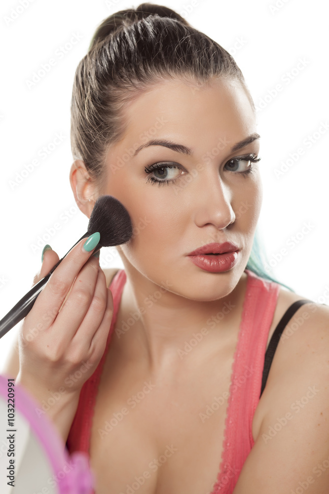 young beautiful woman applied blush on her cheeks young beautiful woman applied blush on her cheeks