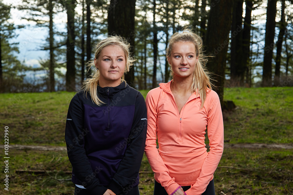 Fototapeta premium Running Women Standing Side by Side in Forest Looking away from