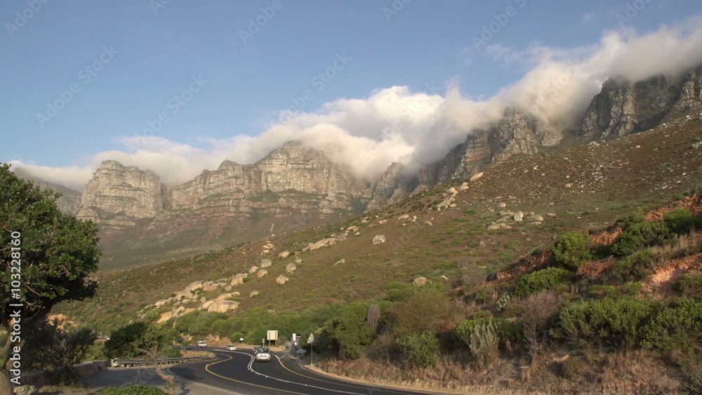 Cars passing on road with 12 Apostle mountains in the background,South Africa Cars passing on road with 12 Apostle mountains in the background,South Africa