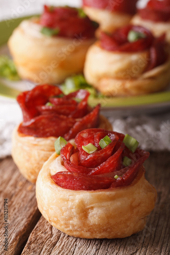 Baked rolls with salami in the form of roses macro. Vertical  