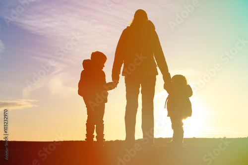 mother and two kids travel at sunset
