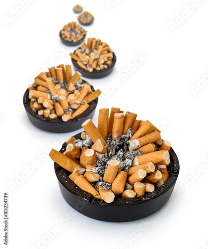 Curve ashtrays full of cigarette butts on a white background