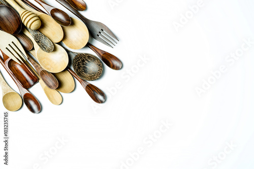 Assorted different kitchen wooden utensils cutlery on a white ba