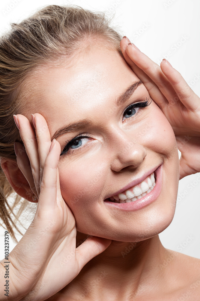 Portrait of a smiling woman with perfect clean skin and natural make up on white background