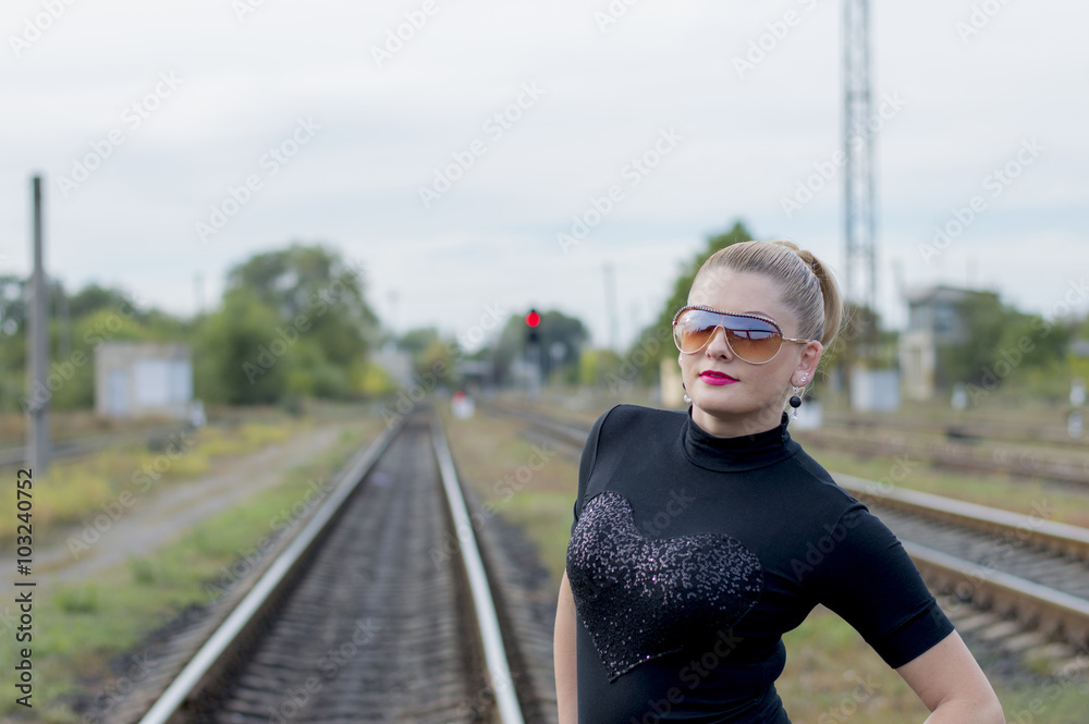 portrait of the cheerful girl in sunglasses against railway trac portrait of the cheerful girl in sunglasses against railway trac