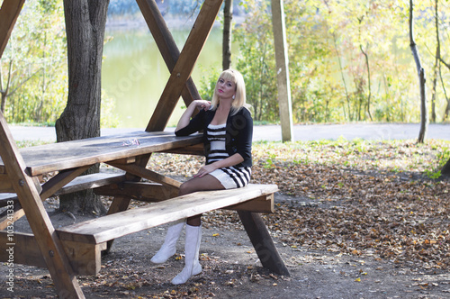 the young girl at a wooden table at the lake